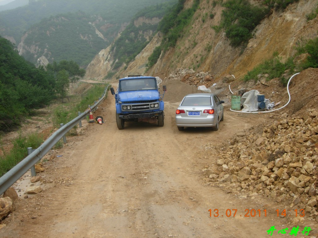 因为路窄这辆大车是从坡上倒车给小车让路的