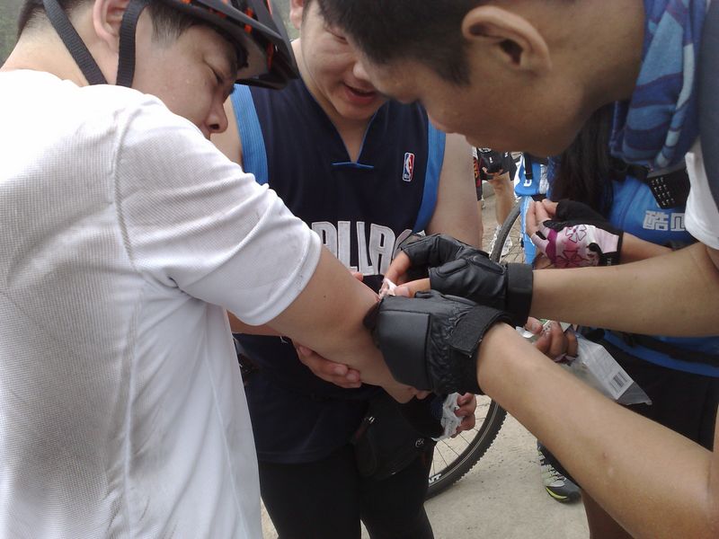 铁牛摔跤了，骑友急忙帮助包扎，医药包是雨儿背的，辛苦了。。。