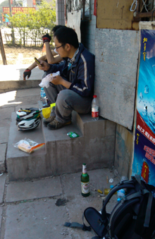 中途 在 一个小商店门口 吃面包 补充能量