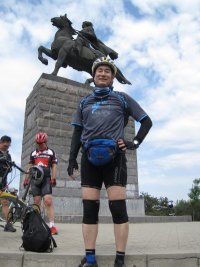 师长李自成塑像前留影，背景车友正在欣赏高级自行车