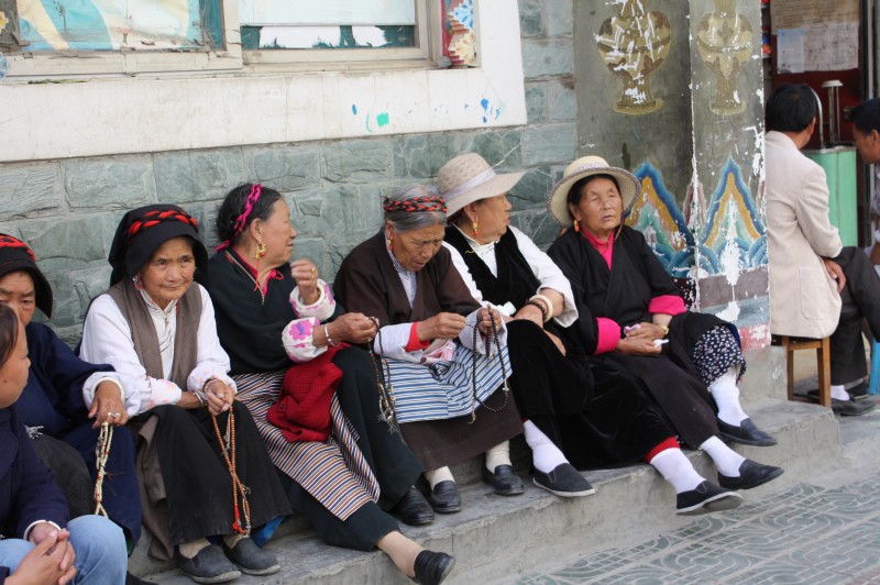 一群老太太数着佛珠坐在一角晒太阳