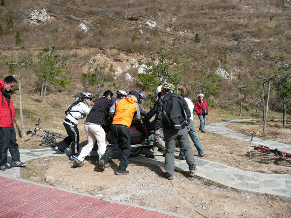 大家一起扶起一辆被风吹倒的开道摩托车