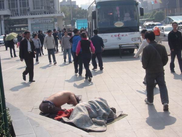 这小伙为救母亲不停的向路人叩头