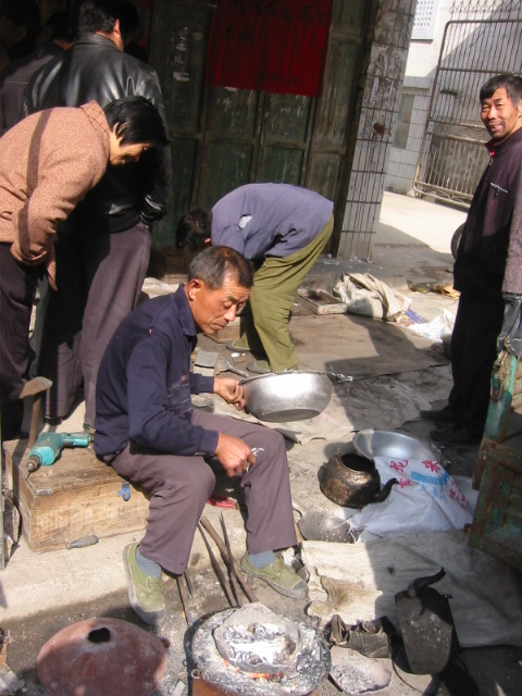 政府门口有人用传统翻砂手工做铝盆