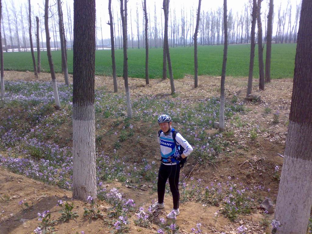 帅哥站在花丛中跟野花比美，嘿嘿！