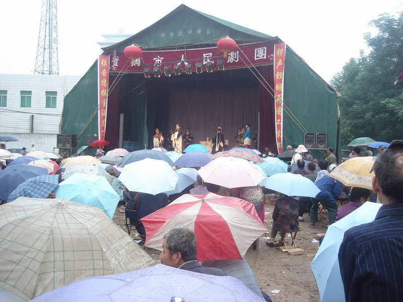 路边群众雨中看秦腔